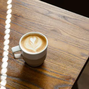 a cup of coffee on a wooden table