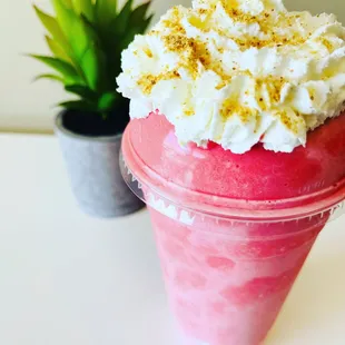 a pink smoothie with whipped cream and sprinkles