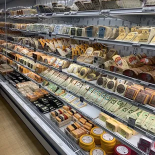 a variety of cheeses in a display case