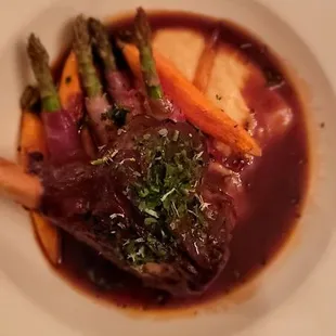 Braised lamb shank prosciutto wrapped asparagus in wine reduction