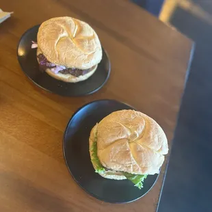 two burgers on black plates