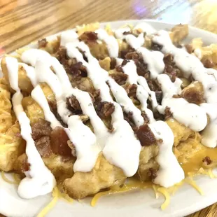 a plate of waffles with bacon and cheese drizzle