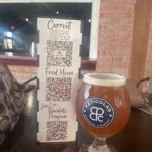 a glass of beer and a menu