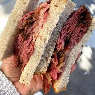 a person holding a sandwich
