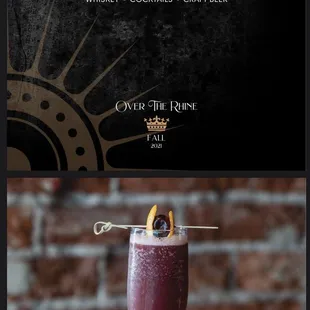 a glass of wine with an orange garnish