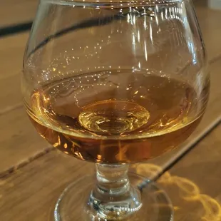 a glass of whiskey on a wooden table