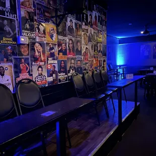 rows of chairs in front of a wall of posters
