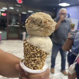 a hand holding a cone of ice cream