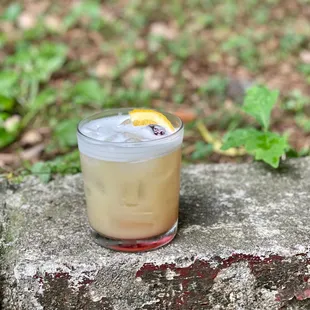 a drink in a glass on a stone ledge