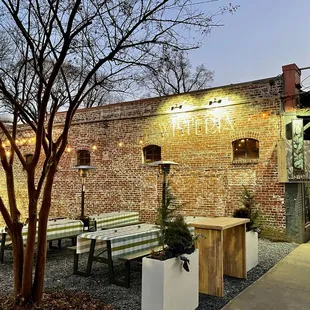 a brick building with benches and tables