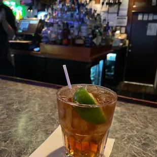 a drink with a lime garnish