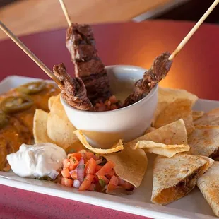 Our Signature Cowboy Sampler, served with Seasoned Steak fajita Skewers, Brisket Quesadillas and Jalapeno Cheese Nachos.