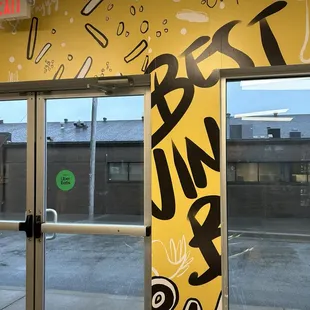 a yellow wall with black and white graffiti