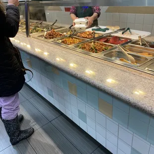 a woman ordering food at a buffet