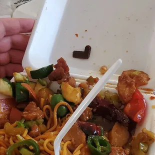 a take out container with noodles and vegetables