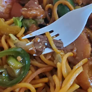a plate of noodles with meat and vegetables