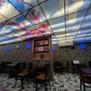 a dining room with a sky painted on the ceiling