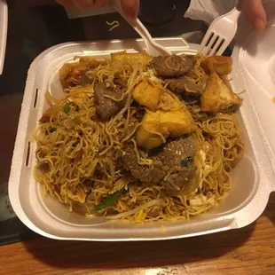 a plate of noodles and meat