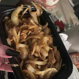 a person holding a container of onions