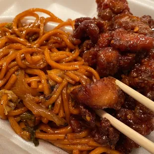 chopsticks and noodles in a styrofoam container