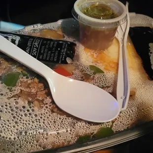 a plastic spoon and spoon rest on a tray