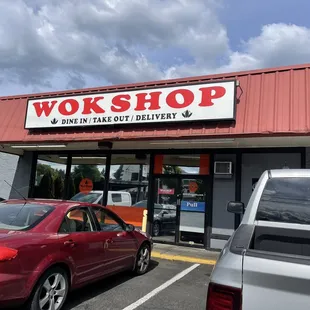 a red car parked in front of the shop