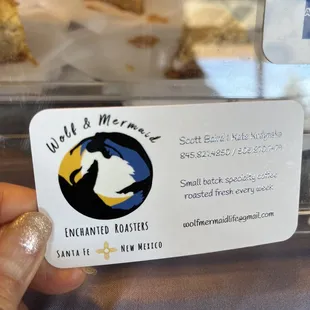 a hand holding a business card
