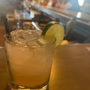 a cocktail with a lime slice