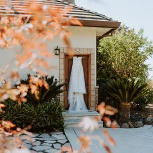 a wedding dress hanging in front of a house