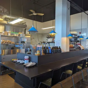 Kitchen area with bar and counter seating plus 3 round tables. Plenty of counter seating facing the windows too.