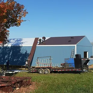 a tractor trailer parked in front of a barn
