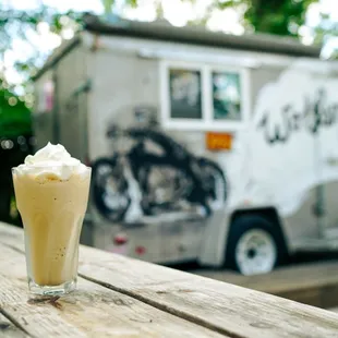 a glass of milkshake on a picnic table