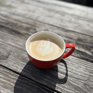 a cup of coffee on a wooden table