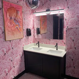a bathroom with pink wallpaper and a mirror