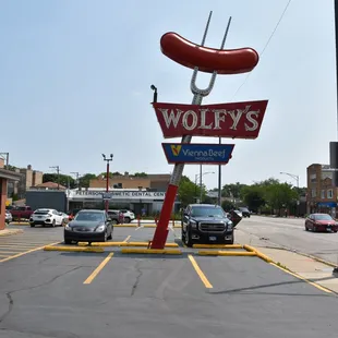 a hot dog sign in a parking lot