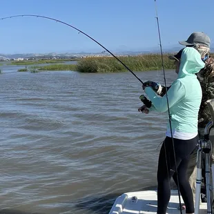 Bob coaching Danielle on how to properly reel in a fish