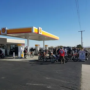 a group of bikers at a gas station