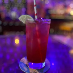 a drink with a straw and a lime slice