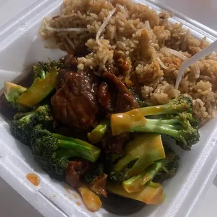 a styrofoam takeout container with rice, broccoli, and meat