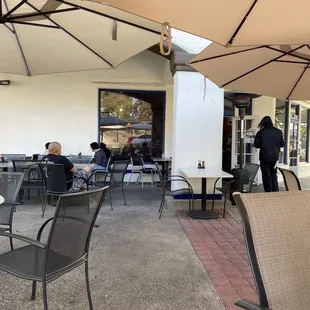 people sitting at tables under umbrellas