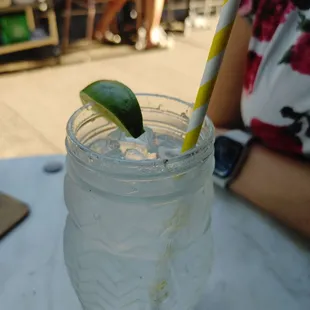 a glass of water with a lime slice in it
