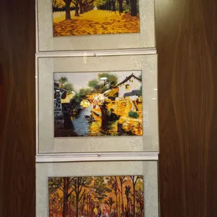 three paintings on a wall