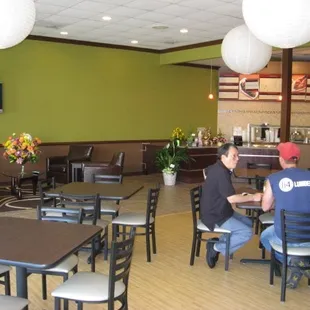 two men sitting at tables in a restaurant