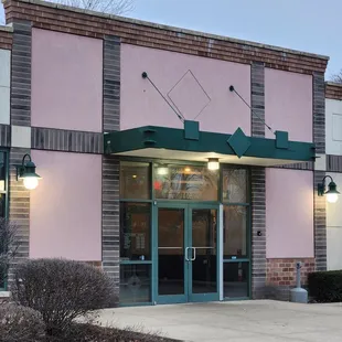 a pink building with a green awning