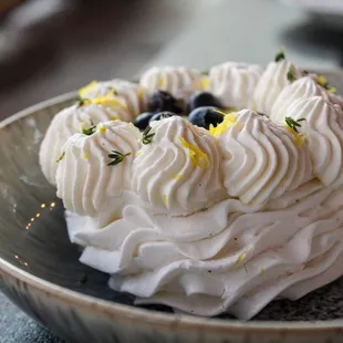 a plate with a cake with whipped cream and blueberries