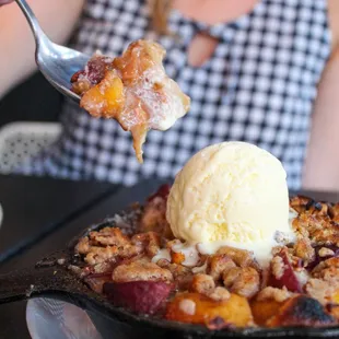 a woman holding a spoon with a scoop of ice cream