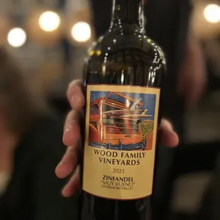 a hand holding a bottle of wine