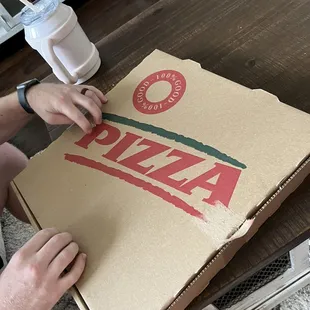 a man cutting a pizza box