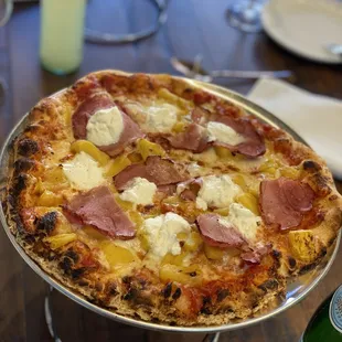 a pizza with ham and cheese