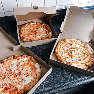 three pizzas in boxes